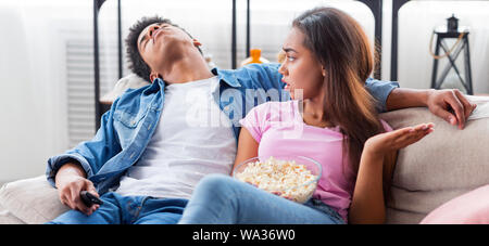 Schwarzer Mann schlief während des Betriebs langweiligen Film zu Hause Stockfoto