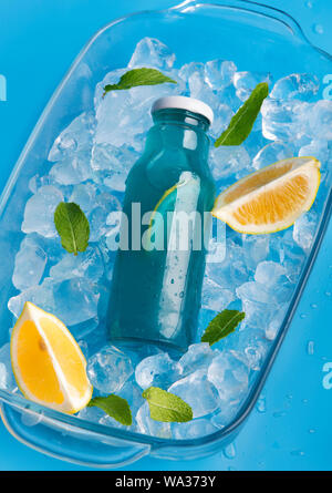 Detox Flasche mit blauem Wasser auf Eiswürfel Hintergrund Stockfoto