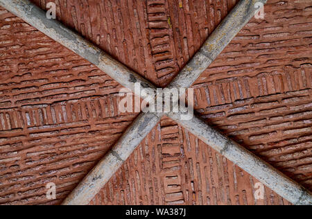 Abstrakte Eindruck, Muster, Struktur durch eine historische Ziegel Decke in ein Gewölbe mit einem gekreuzten grau Tragkonstruktion Stockfoto