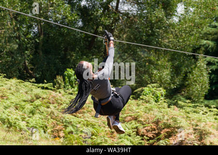 Eine junge kenianische Frau reisen auf einem Zip Line im Forest Recreation Center, Kenia Stockfoto