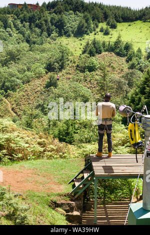 Eine Frau, die auf ein Zip Line im Forest Recreation Center mit Führung am Ende warten, Kenia Stockfoto