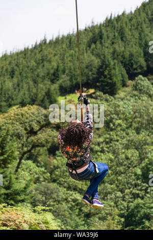 Eine junge kenianische Frau reisen auf einem Zip Line im Forest Recreation Center, Kenia Stockfoto