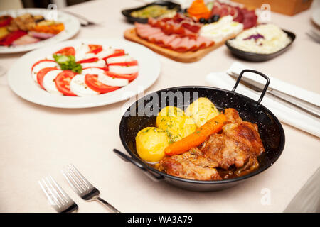 Rindfleisch mit gekochten Kartoffeln und Karotten in einem Metallbehälter serviert, gekocht, Ansicht von oben Stockfoto
