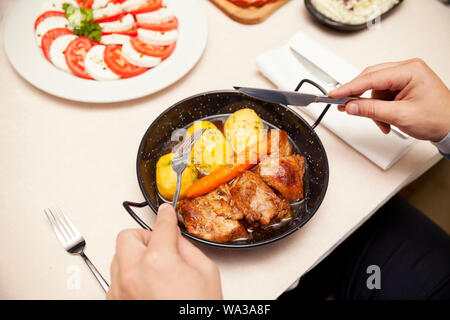 Rindfleisch mit gekochten Kartoffeln und Karotten in einem Metallbehälter serviert, gekocht, Ansicht von oben Stockfoto