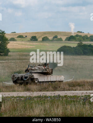 Ein M1 Abrams Tank vom 3. Battalion, 66th Panzer Regiment, 1. gepanzerte Brigade Combat Team, 1.Infanterie Division, Brände auf Pop-up Ziele während einer kombinierten Waffen Training übung auf einer Strecke an grafenwöhr Training Area, Germany, August 8, 2019. Diese Übung ist Teil der 1 letzten Training ABCT vor der Teilnahme an der Veranstaltung kombiniert Lösen XII. (U.S. Armee Foto: Staff Sgt. Adam Decker) Stockfoto