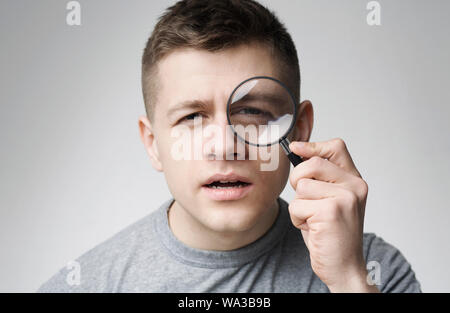 Neugierige junge Menschen durch die Lupe suchen Stockfoto
