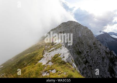 Frau Wandern auf dem Berg mit dramatischen ansehen und bewölktem Himmel Stockfoto