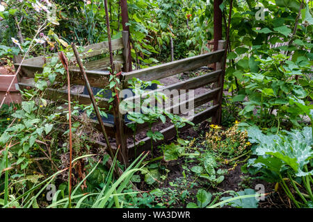 Holz- komposter im Garten overgrowing Stockfoto