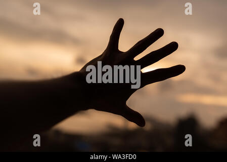 Einen Mann zu erreichen, hin zu dunklen Himmel. Stockfoto