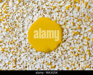 Grenze von Popcorn über Gelb Hintergrund mit Kopie Raum verstreut, Ansicht von oben. Minimalistisches Design für Film Poster, Unterhaltung Konzept. Nahaufnahme der Stockfoto