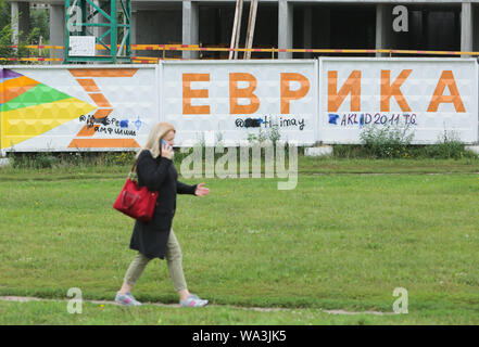 Kiew, Ukraine. 17 Aug, 2019. Eine Frau geht hinter den Zaun um Baustelle mit Drogenhandel Telegramm Kanäle in Kiew, Ukraine, August 17, 2019 geschrieben. Die Ukraine hatte erfasst eine israelisch-amerikanische Amos Dov Silber in einer großen Online - Drogenhandel Netzwerk- und drei SBU (Security Service der Ukraine) Mitarbeiter, die im Verdacht stehen, helfen, Silber escape von Kiew Flughafen Borispol während des Prozesses der seine Auslieferung vermutet. Credit: sergii Kharchenko/ZUMA Draht/Alamy leben Nachrichten Stockfoto