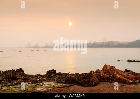 Die Stadt im Nebel wird durch das Meer, Qingdao, China. Stockfoto