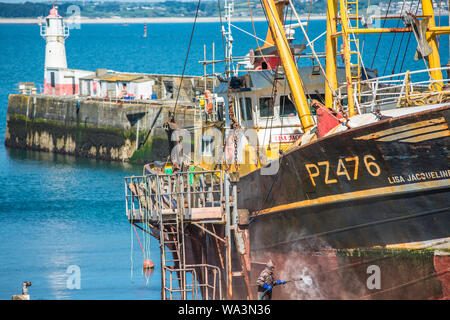 Alte Fischtrawler mit gedrueckt Wasserstrahl auf Newlyn Fischerdorf in der Nähe von Penzance in Cornwall, England, Großbritannien. Stockfoto