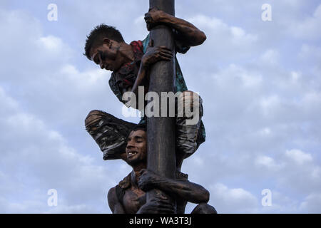 Lhokseumawe, Aceh, Indonesien. 17 Aug, 2019. Der Teilnehmer trägt das Gewicht von anderen Männern, wie sie versuchen, die Preise in eine gefettete-Pole Climbing Wettbewerb als Teil der gefeierten Indonesien 74th Tag der Unabhängigkeit in Lhokseumawe zu erreichen. Indonesien die Unabhängigkeit von der niederländischen Kolonialismus in 1945 und jetzt 2019 ist der 74. Jahrestag der Unabhängigkeit von Indonesien. Credit: zikri Maulana/ZUMA Draht/Alamy leben Nachrichten Stockfoto