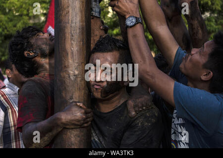 Lhokseumawe, Aceh, Indonesien. 17 Aug, 2019. Der Teilnehmer trägt das Gewicht von anderen Männern, wie sie versuchen, die Preise in eine gefettete-Pole Climbing Wettbewerb als Teil der gefeierten Indonesien 74th Tag der Unabhängigkeit in Lhokseumawe zu erreichen. Indonesien die Unabhängigkeit von der niederländischen Kolonialismus in 1945 und jetzt 2019 ist der 74. Jahrestag der Unabhängigkeit von Indonesien. Credit: zikri Maulana/ZUMA Draht/Alamy leben Nachrichten Stockfoto