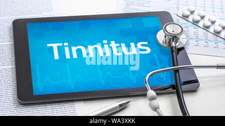 Das Wort Tinnitus auf dem Display eines Tablet Stockfoto