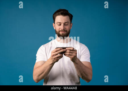 Bild des jungen Mannes mit einem Smartphone und lächelnd. Bei smartphone. Kommunikation. Stockfoto