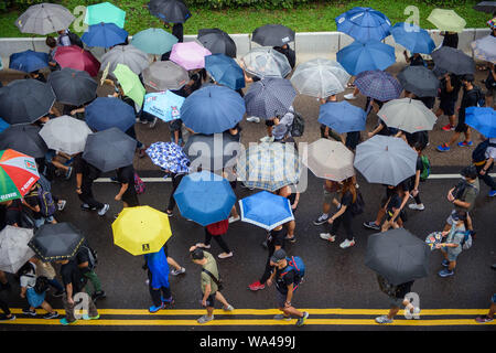 17. August 2019, China, Hongkong: Teilnehmer an einem Protestmarsch durch die Hongkongs Stadtteil Kowloon und selbst mit Sonnenschirmen vor dem Regen schützen. Neue protest Wochenende in Hongkong: Zehntausende Anhänger der Demokratie wieder ziehen sie durch die Stadt. Und an diesem Sonntag (18.08.2019) gibt es sogar noch mehr werden. Foto: Gregor Fischer/dpa Stockfoto