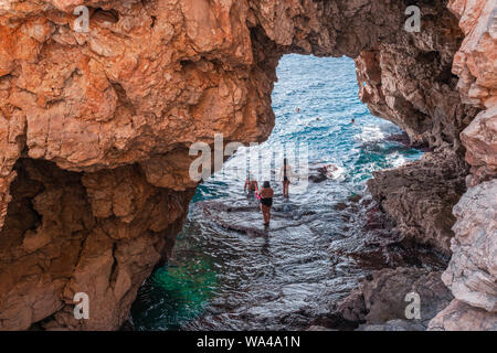 Passage unter dem Felsen am malerischen Strand der Lagune mit türkisblauem Wasser in Javea, Alicante, Spanien. Stockfoto