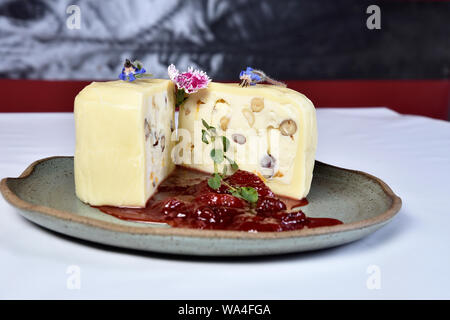 Mozzarella gefüllt mit Muttern in die Hälfte geschnitten mit Erdbeermarmelade. Stockfoto