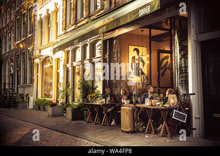 AMSTERDAM, NIEDERLANDE, 31. AUGUST 2018: Street Scene aus Amsterdam mit Menschen Speisen im Freien bei Sonnenuntergang. Stockfoto