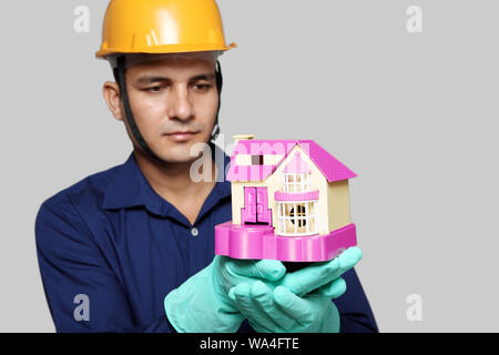 Klempner zeigt Modell von Traumhaus Stockfoto