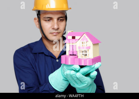 Klempner zeigt Modell von Traumhaus Stockfoto
