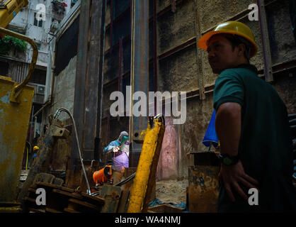 Hongkong, China. 17 Aug, 2019. Ein Bauarbeiter schweißt ein Stahlträger in einem Abstand auf einer Baustelle. Credit: Gregor Fischer/dpa/Alamy leben Nachrichten Stockfoto