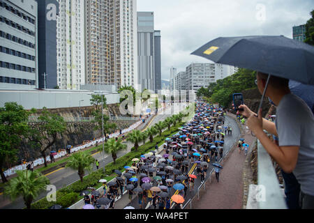Hongkong, China. 17 Aug, 2019. Die Teilnehmer an einem Protestmarsch durch die Hongkongs Stadtteil Kowloon und selbst mit Sonnenschirmen vor dem Regen schützen. In Hongkong gab es massive Proteste für mehr als zwei Monate. Die Demonstrationen wurden durch eine Gesetzesvorlage der Regierung ausgelöst - jetzt in der Warteschleife - Verdacht auf Auslieferung von Verbrechern zu China. Credit: Gregor Fischer/dpa/Alamy leben Nachrichten Stockfoto