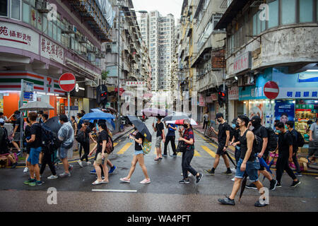Hongkong, China. 17 Aug, 2019. Die Teilnehmer an einem Protestmarsch durch die Hongkongs Stadtteil Kowloon und selbst mit Sonnenschirmen vor dem Regen schützen. In Hongkong gab es massive Proteste für mehr als zwei Monate. Die Demonstrationen wurden durch eine Gesetzesvorlage der Regierung ausgelöst - jetzt in der Warteschleife - Verdacht auf Auslieferung von Verbrechern zu China. Credit: Gregor Fischer/dpa/Alamy leben Nachrichten Stockfoto