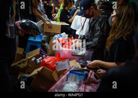 Hongkong, China. 17 Aug, 2019. Ein Demonstrator untersucht die Güter der Anhänger der Proteste, Atemschutzmasken, Handschuhen und anderen Geräten am Straßenrand in Hongkongs Stadtteil Kowloon verkaufen. In Hongkong gab es massive Proteste für mehr als zwei Monate. Die Demonstrationen wurden durch eine Gesetzesvorlage der Regierung ausgelöst - jetzt in der Warteschleife - Verdacht auf Auslieferung von Verbrechern zu China. Credit: Gregor Fischer/dpa/Alamy leben Nachrichten Stockfoto