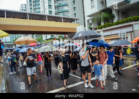 Hongkong, China. 17 Aug, 2019. Die Teilnehmer an einem Protestmarsch durch die Hongkongs Stadtteil Kowloon und selbst mit Sonnenschirmen vor dem Regen schützen. In Hongkong gab es massive Proteste für mehr als zwei Monate. Die Demonstrationen wurden durch eine Gesetzesvorlage der Regierung ausgelöst - jetzt in der Warteschleife - Verdacht auf Auslieferung von Verbrechern zu China. Credit: Gregor Fischer/dpa/Alamy leben Nachrichten Stockfoto