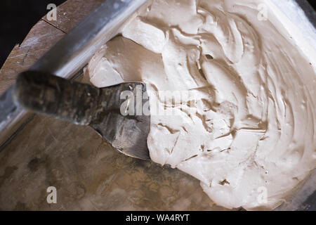 Finishing arbeitet mit Festlegung der Keramikfliesen. Eimer mit putty für Kachel Nähte. 2-Komponenten dekorative, säurebeständigen Epoxidharz vergießen. Stockfoto