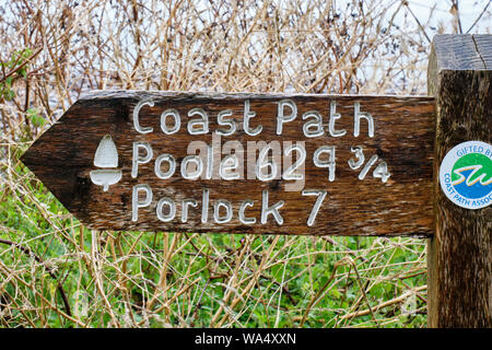 Wegweiser auf dem South West Coast Path in MInehead, Someset, zeigen auf den Hafen von Poole in Dorset. Stockfoto