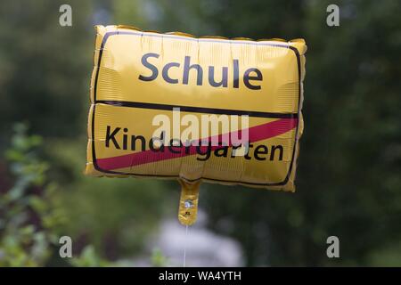 Dresden, Deutschland. 17 Aug, 2019. An einem Ballon hängt in einem Garten, der wie ein Ort konzipiert ist - Namen unterzeichnen, das Wort 'Schule' ist an der Oberseite und die Durchgestrichenen Wort 'Kindergarten' unten geschrieben. Credit: Sebastian Kahnert/dpa-Zentralbild/dpa/Alamy leben Nachrichten Stockfoto