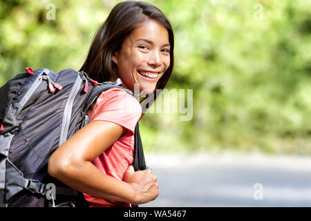 Glückliche junge asiatische Chinesische Rucksack Mädchen Student. Nette erwachsene Frau Backpacker an Kamera lächelnd mit Schultasche tun Sommer wandern Reisen in die Natur. Stockfoto