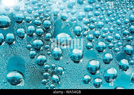 Wasser Flitter und Tropfen auf Kunststoff blau pottle Oberfläche Stockfoto