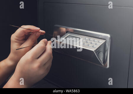 Nahaufnahme der Dieb die Hände versuchen zu brechen Home Geld sicher und Raub. Sicherheit und Home Security Konzepte. Stockfoto