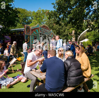 Menschen entspannend auf dem George Square Gardens auf der belebten sonnigen Tag in Edinburgh Festival Fringe, Schottland, Großbritannien Stockfoto