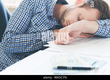 Überarbeitet und müde im Büro schlafen über bei der Arbeit am Tisch im Büro Stockfoto