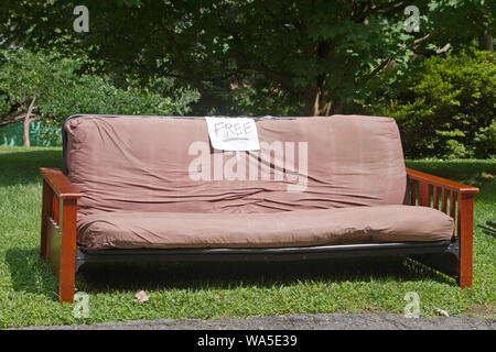 Ein Futon Couch oder Bett mit einem freien Zeichen von der Straße einzudämmen weg gegeben werden Links Stockfoto