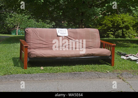 Ein Futon Couch oder Bett mit einem freien Zeichen von der Straße einzudämmen weg gegeben werden Links Stockfoto