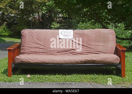 Ein Futon Couch oder Bett mit einem freien Zeichen von der Straße einzudämmen weg gegeben werden Links Stockfoto