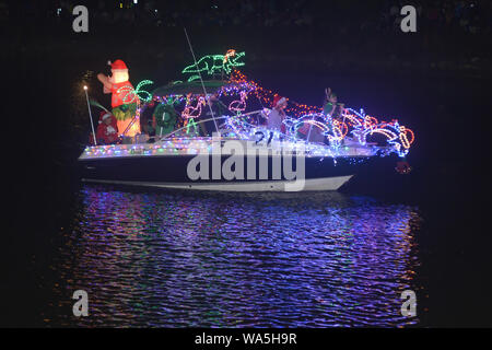 Ein Boot mit Urlaub Nachtschwärmer Fahrt auf einem Boot in Weihnachtsbeleuchtung in Venice, Florida während Urlaub Boot Parade eingerichtet. Stockfoto