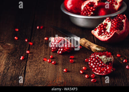 Granatapfel Obst mit Messer auf Holzmöbeln im Landhausstil Oberfläche. Stockfoto