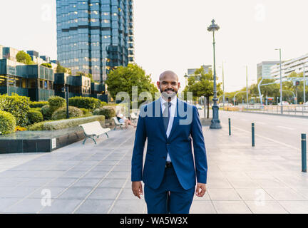 Indischer Geschäftsmann trägt blaue Anzug zu Fuß in der Nähe von Büro oder Hotel Stockfoto