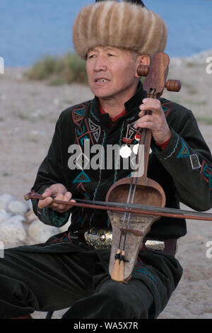 Issyk Kul, Kirgisistan - Mai 28, 2017 - Musiker spielt traditionelle Komuz bundlosen Saiteninstrument Stockfoto