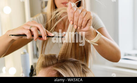 Weibliche Friseur, Frisur, blondes Mädchen im Beauty Salon. Detailansicht. Friseurdienstleistungen. Erstellen von Frisur. Hair Styling. Stockfoto