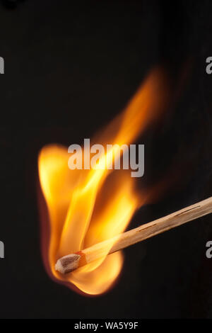 hölzerne Streichholz anzünden in Flammen auf schwarzem Hintergrund Stockfoto