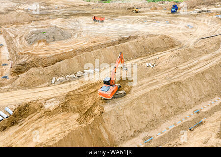 Blick von oben auf die industriellen Bagger und Kipper auf der Baustelle arbeiten Stockfoto